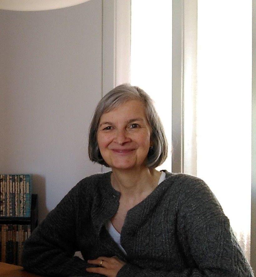 Portrait Birgit Mills lächelnd am Schreibtisch